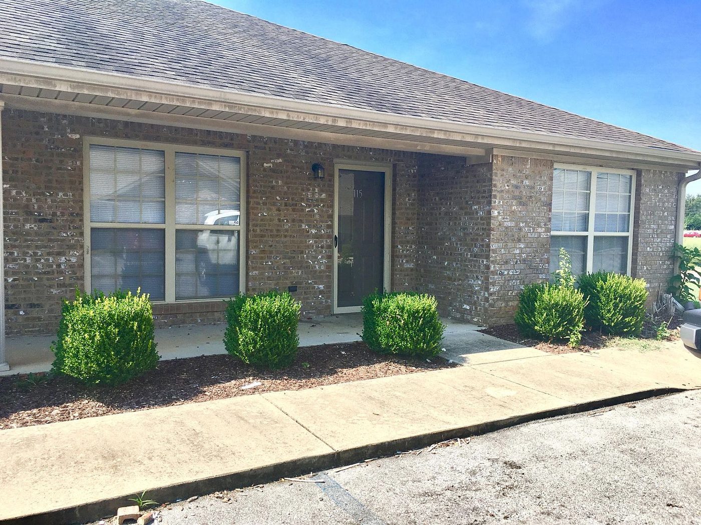 Pinebrook Apartments brick building exterior with covered entrances, Florence Alabama