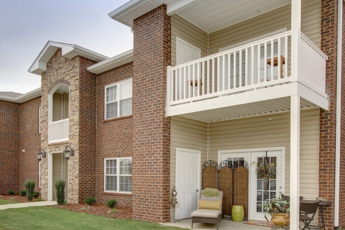 Furnished covered patio with stacked-stone accents at Seville Place, Florence Alabama